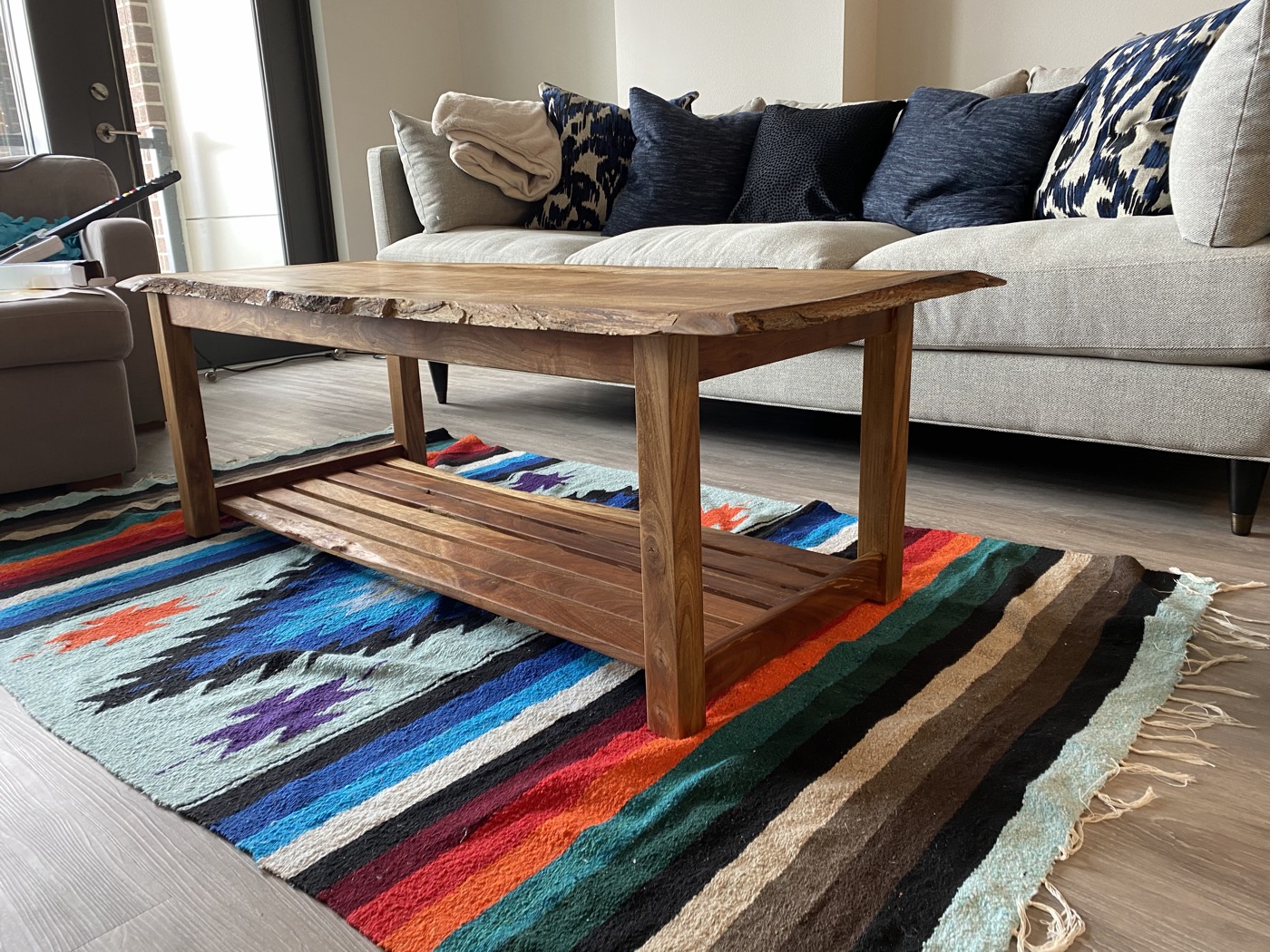 Live-edge walnut coffee table with lower slatted shelf in living room