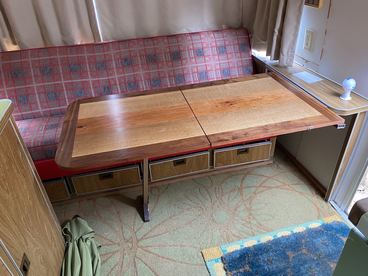 Custom walnut-bordered dinette table fitted inside a vintage camper