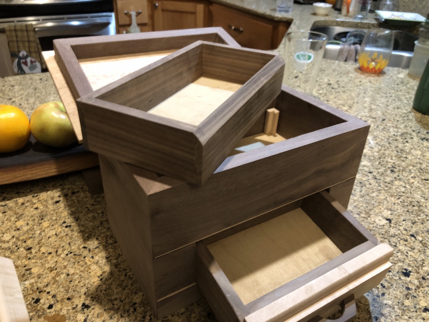 Set of handcrafted walnut jewelry boxes with drawers on kitchen counter